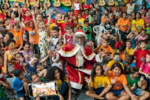 Papai Noel negro distribui livros para crianças do Caju e Cidade de Deus